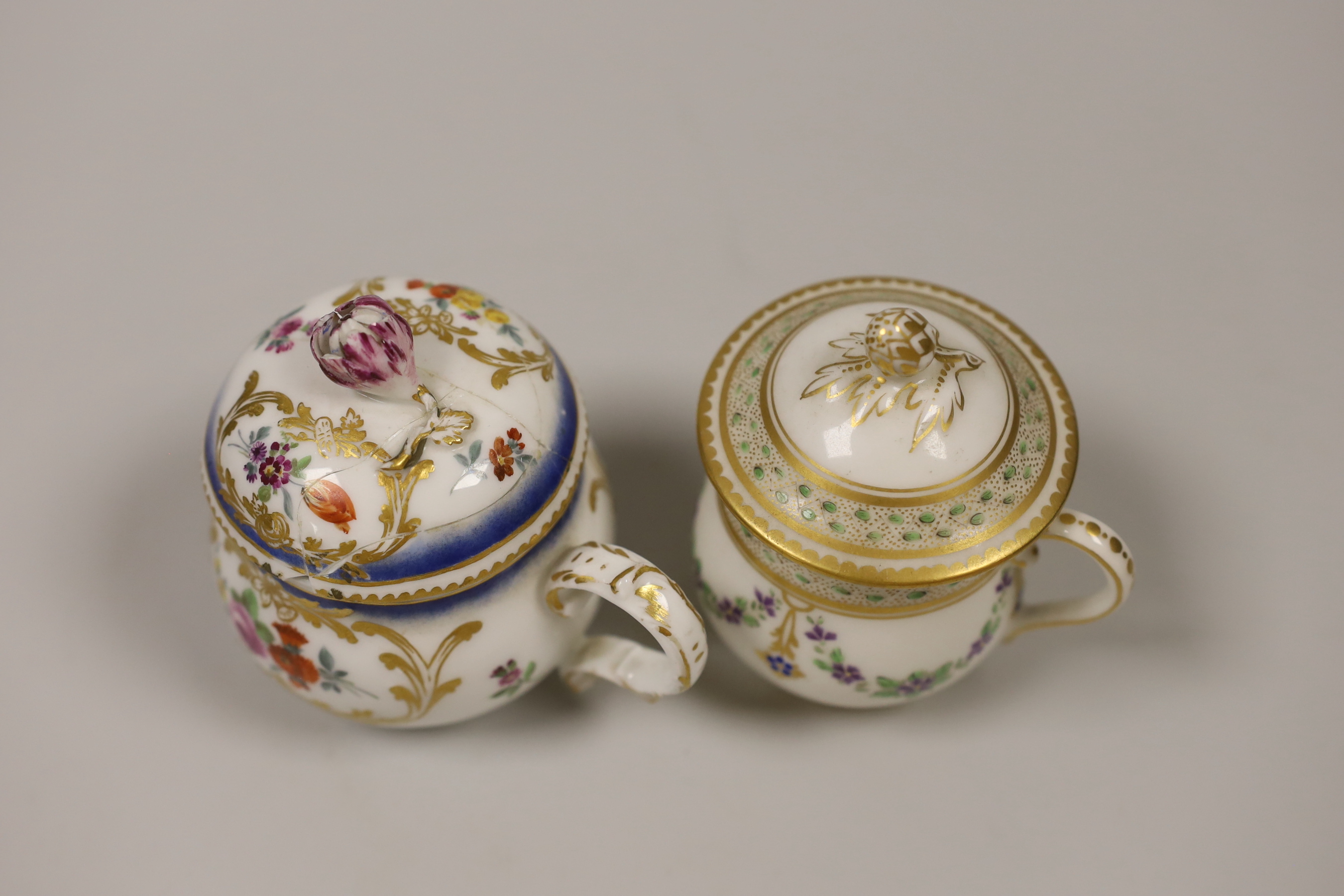 An 18th century Meissen custard cup and cover painted with flowers in Sevres style, crossed swords dot in blue, and a 19th century Paris porcelain custard cup and cover painted with chains of flowers, the largest 9cm hig